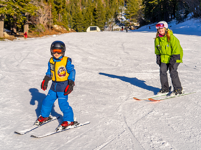 Kid and instructor skiing